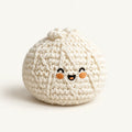 Single cream knitted bun footbag with embroidered smiling face on an ivory background