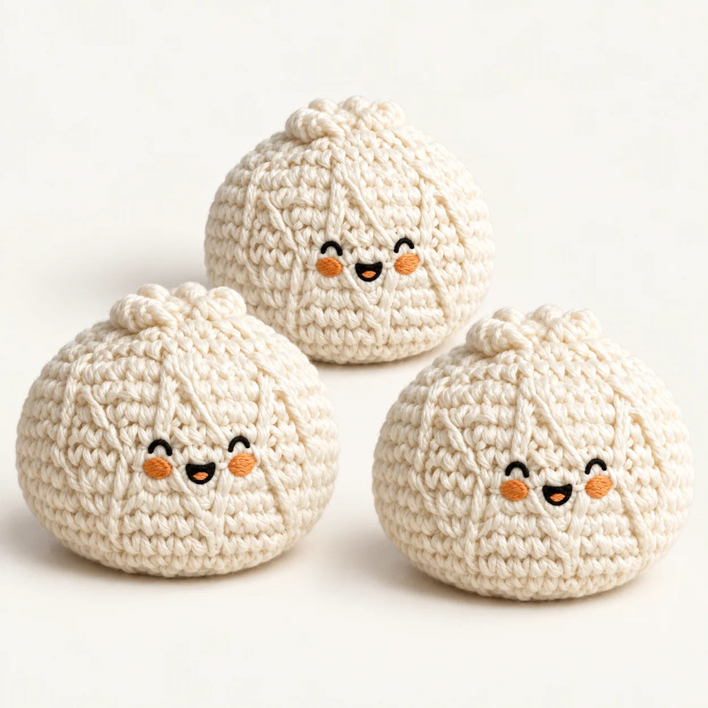 Pack of three cream knitted bun footbags with embroidered smiling faces